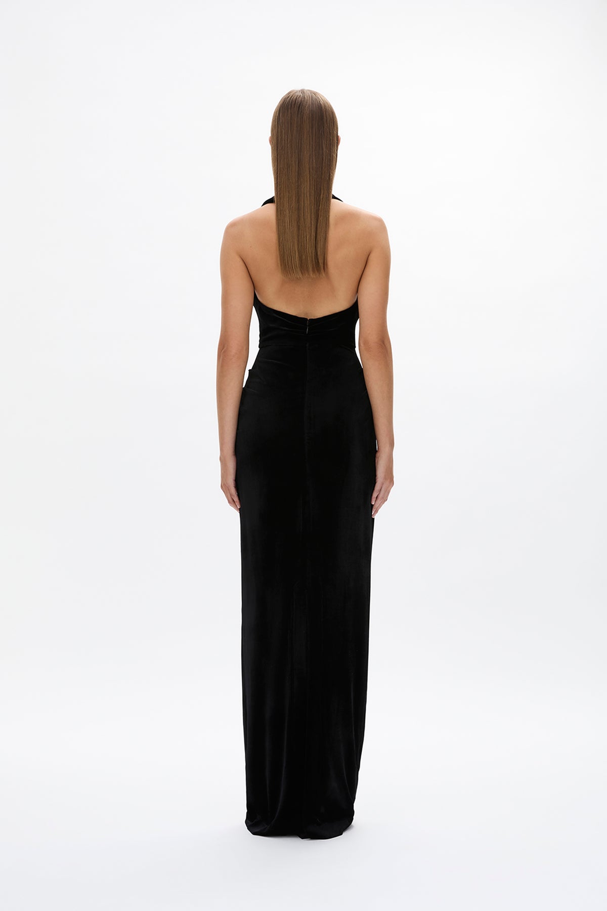 Back image of model wearing Rachel Gilbert Martin Plunge Gown, black velvet halter gown with deep plunge neckline and internal corset.