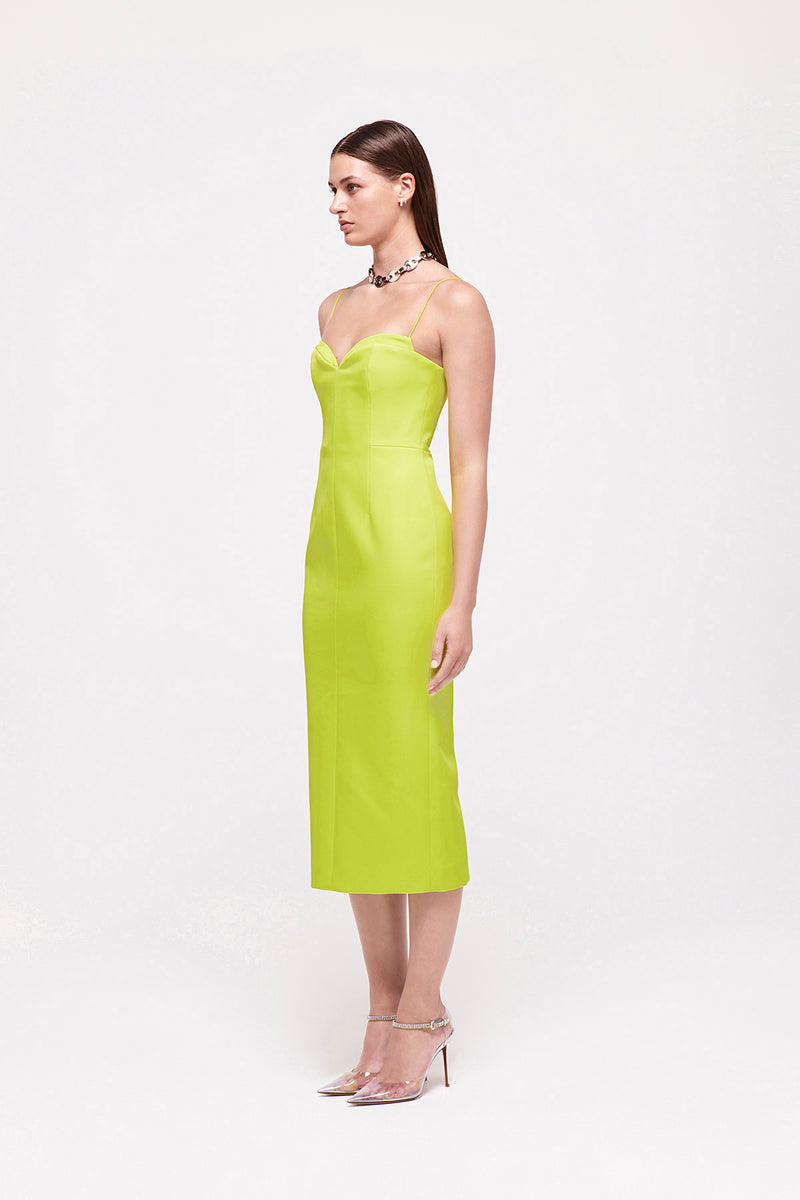 Side on image of model wearing Bodie Dress in Neon featuring sweetheart neckline and thin straps, falling to a mid-length silhouette.